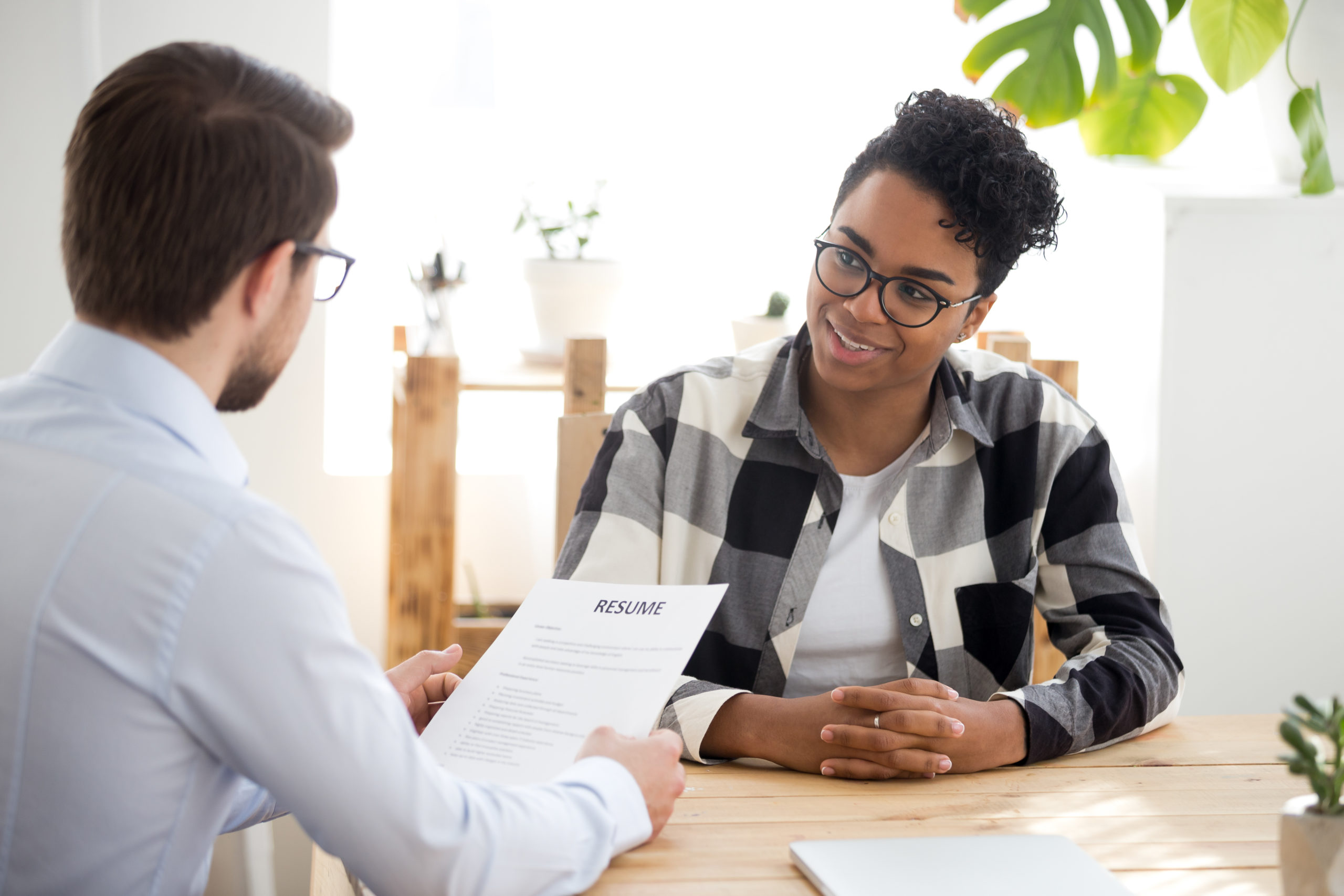 Run From a Job Offer, a job with red flags. Male employer holding resume talking with African American female job candidate at interview, black millennial girl recruitment process, speak with HR manager, businessman consider applicant cv