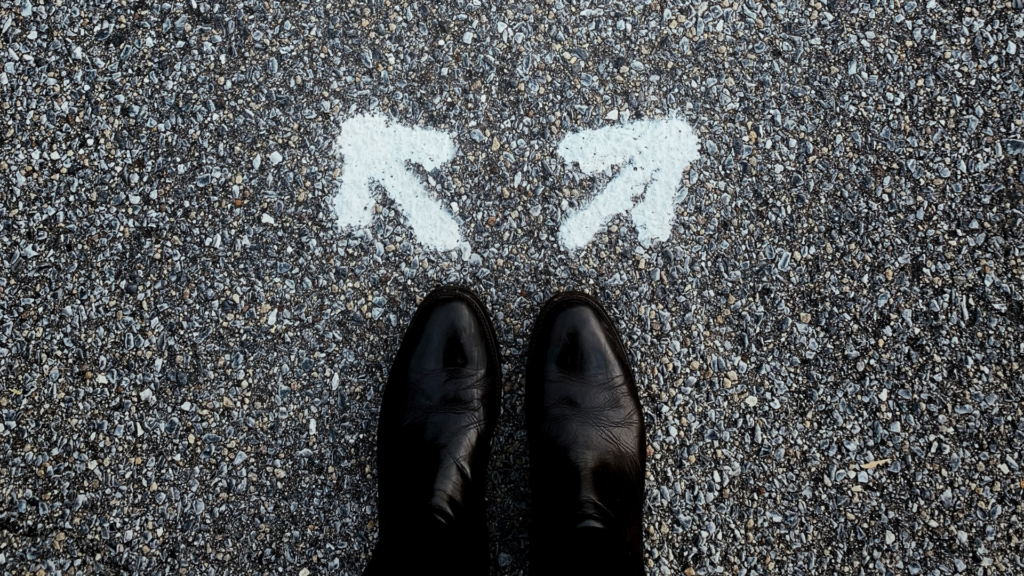 Person standing behind two arrows going opposite directions