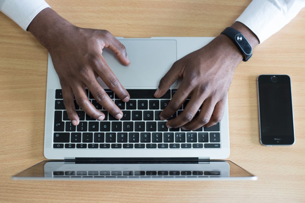 Man writing an email at computer, professional email etiquette