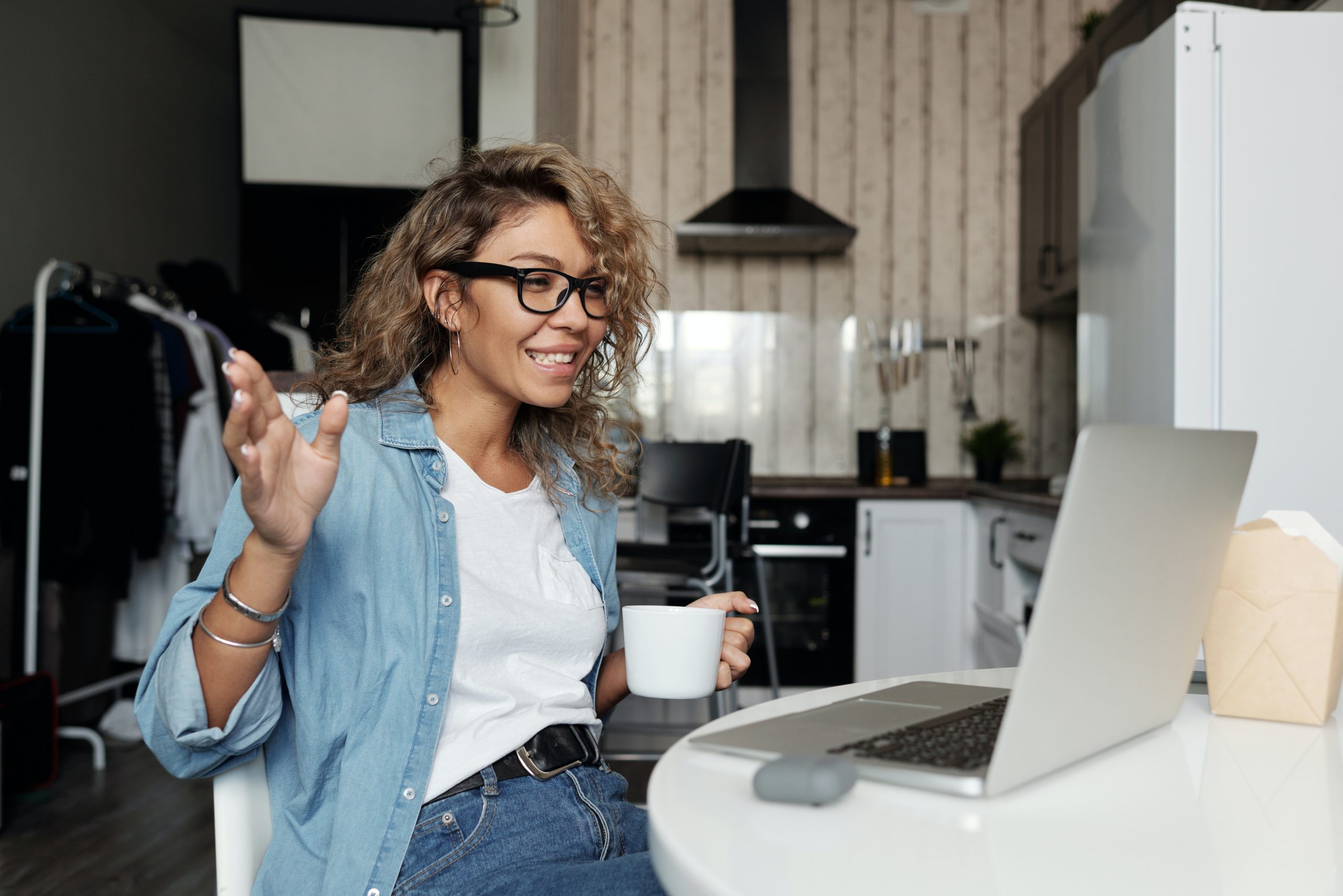 Woman holding coffee having a video call; best practices for giving constructive criticism
