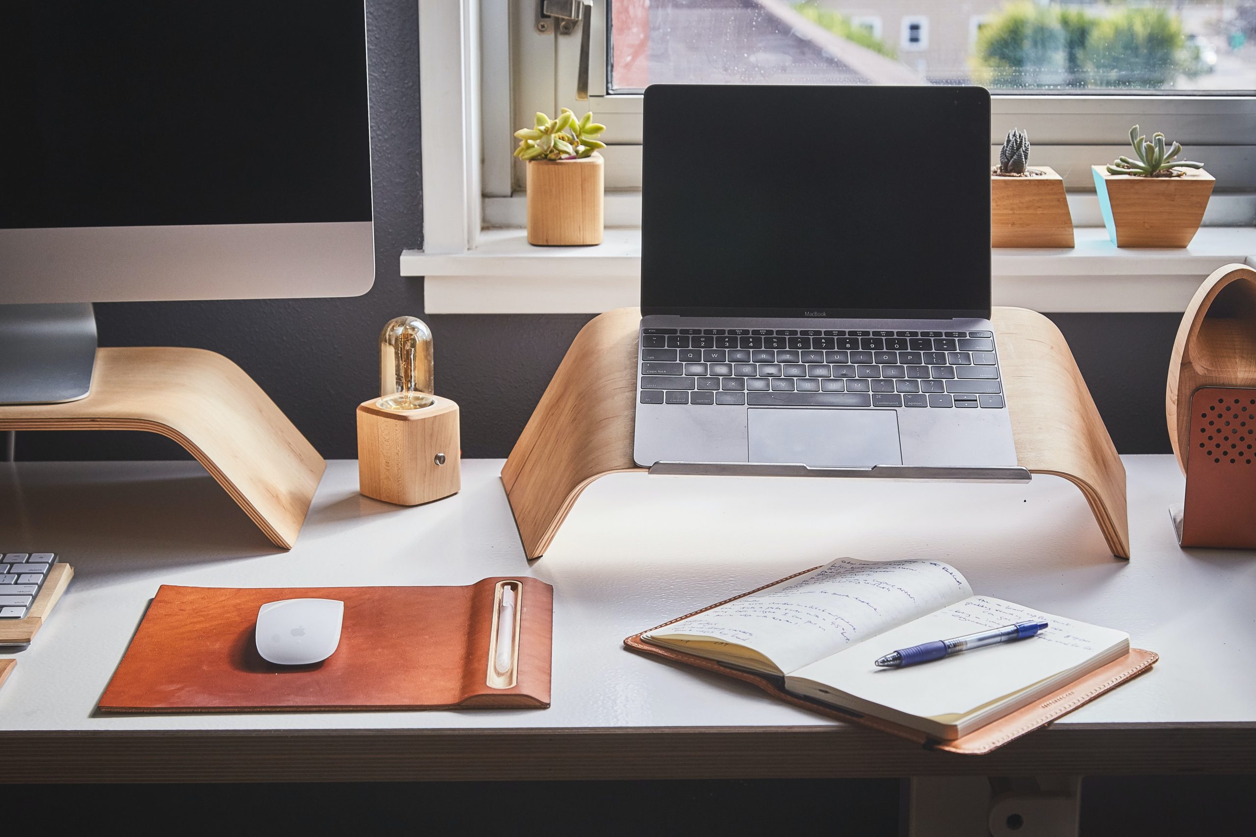 A desk with a computer, laptop, and a notebook, Stay Organized at Work